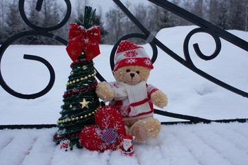 Cute brow teddy bear on white snow brackground