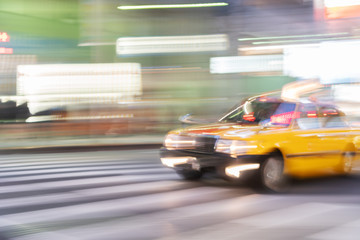 Speed motion abstract blurred of taxi with neon urban night light at shinjuku road in tokyo japan...