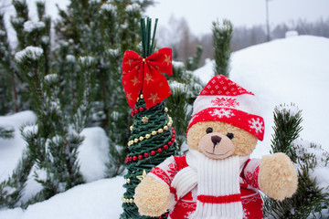 Cute brow teddy bear on white snow brackground