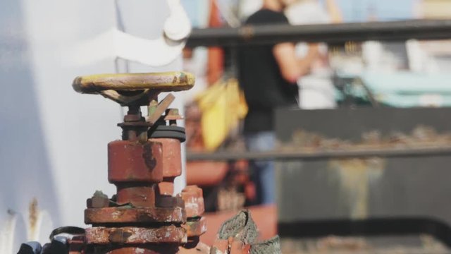 Yellow valve in thin red rusty pipes in sea ship. Machinery and equipment of a ship.