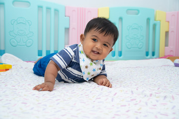 Cute little asian baby lying and crawling on floor