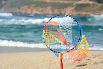 Fishing net for children fixed on the sand