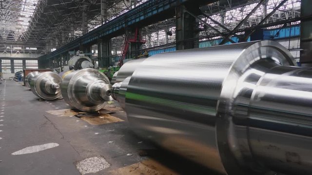 Rolls of steel lie on floor in production workshop of plant. Manufacture of steel products. Rolling forming rolls metal works. Rolling mill preparation workshop. Machining of machine parts