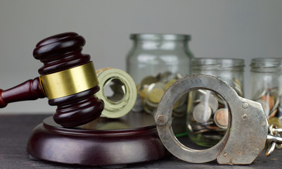 Bribery and corruption problems concept.Judge's gavel and police handcuffs with roll of money.
