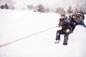 group of young people pulling a rope in tug of war competition