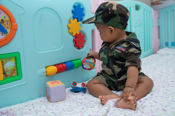 Cute little asian baby in Military uniform play toy