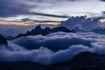 Stunning sunset over mountain alpine landscape and high summits or peak of Gosaukamm ridge, Dachstein. Sunset or sunrise colors in Alps, low clouds, motion blurr. Dreamy landscape.