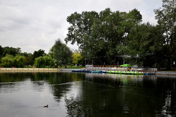 Moscow, Russia - August 21, 2019: Pond in the Gorky Park with boat rental station and a cafe in the background on a cloudy summer day