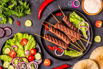 Traditional middle eastern, arabic or mediterranean meat kebab with vegetables and pita bread.