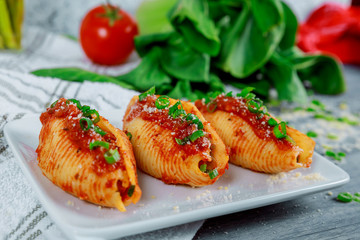 Pasta shells stuffed with ricotta cheeses, tomato sauce and chives.