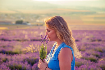 Girl in a lavender field at sunset. Sunny summer evening in Crimea.