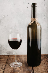 Red wine, glass and bottle on a stucco wall