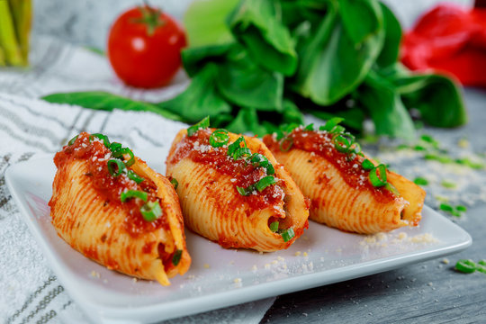 Pasta shells stuffed with ricotta cheeses, tomato sauce and chives.