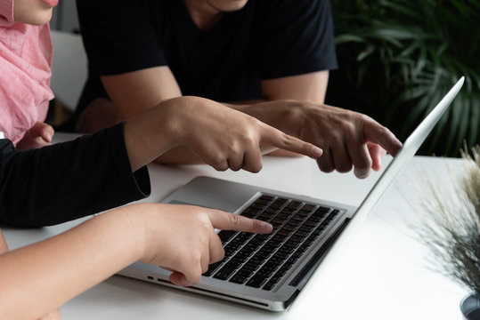 Two asian teenage man,woman and adult man sit , look ,point laptop together in library room at school,fun and happy,education concept,learning and knowlage.white background.