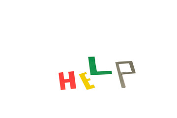 Word "Help" form different color letters (red, yellow, green, grey) is on the white table/background. International Volunteer Day