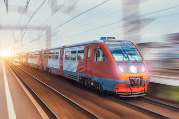 Obraz premium Pociąg pasażerski jedzie z efektem rozmycia ruchu kolejowego.
