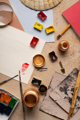 Artist's workspace flatlay. Art equipment on rustic background. Top view with copy space.