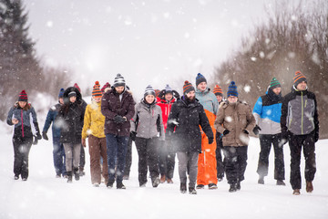 group of young people walking through beautiful winter landscape
