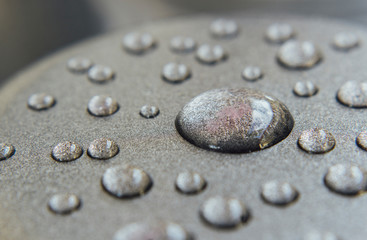 Fototapeta na wymiar Water droplets on a gray surface
