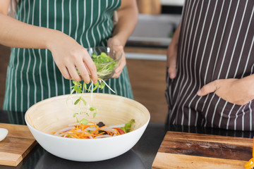 Young Asian couple preparing vegetable for make a fresh salad for their lunch