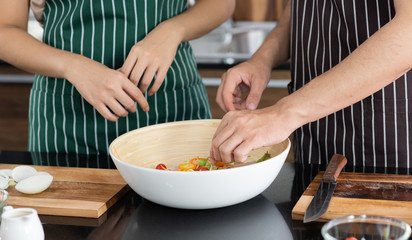 Young Asian couple preparing vegetable for make a fresh salad for their lunch