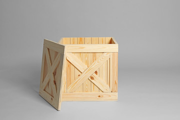 One open wooden crate on grey background
