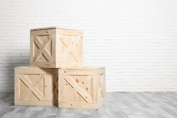 Wooden crates on floor at white brick wall. Space for text