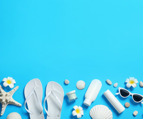 Flat lay composition with stylish beach accessories on light blue background, space for text