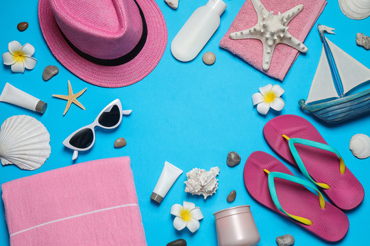 Flat lay composition with stylish beach accessories on light blue background, space for text