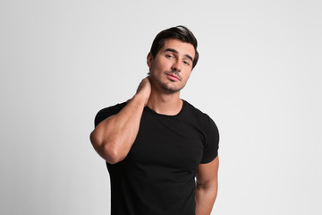 Portrait of handsome young man in black t-shirt on grey background