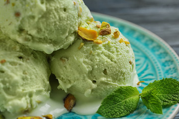 Delicious green ice cream served on blue plate, closeup