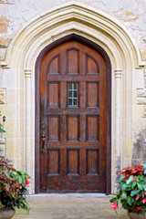 Fototapeta na wymiar Old Wooden Door with Arched Doorway on Historic Stone Building