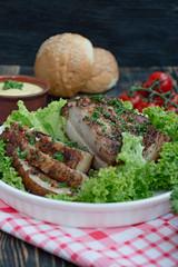 Baked pork belly with spices. Sliced breast, served with greens. Traditional dish of Ukraine.