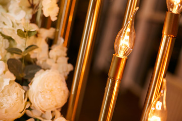 Decorative elements for a wedding. Garland of vintage lamps and a bouquet of white flowers.