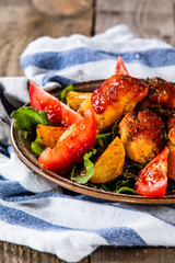 Fried chicken nuggets, baked potatoes and vegetable salad