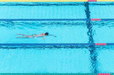 Top view shot of sportswoman swimming freestyle in a race