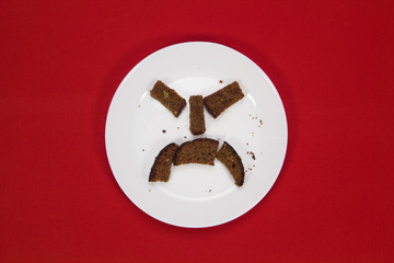 Rusk on a white plate on a red background