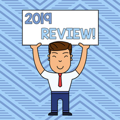 Word writing text 2019 Review. Business photo showcasing remembering past year events main actions or good shows Smiling Man Standing Holding Big Empty Placard Overhead with Both Hands