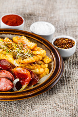 Grilled sausages, French fries and vegetables