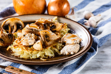 Potato cakes with chopped pork, gravy sauce and champignon