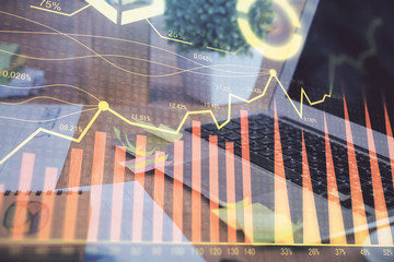 Double exposure of graph and financial info and work space with computer background. Concept of...