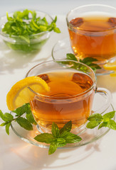 Black tea with mint and lemon on a white table