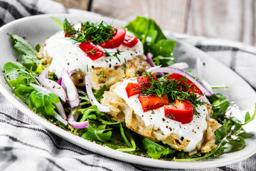 Potato cakes with sour cream and vegetables