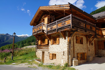 Fototapeta na wymiar Mountain chalet with traditional architecture and décorated balconies in a high village of the Alps, France