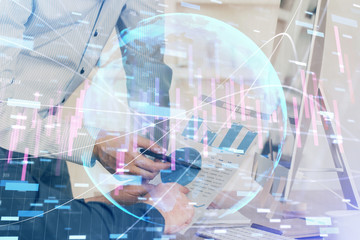 Double exposure of chart with businessman typing on computer in office on background. Concept of hard work.