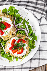 Potato cakes with sour cream and vegetables