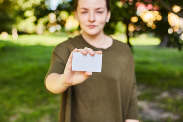 Girl holding a white credit card in her hands for shopping. 