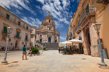 Some tourists visiting the baroque cathedral in the historic center of Ragusa Ibla in Sicily, Italy.