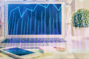 Forex market graph hologram and personal computer on background. Multi exposure. Concept of investment.