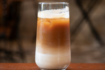 Delicious iced cafe latte on wooden table.